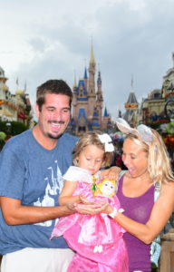 a man holding a little girl in front of a castle.